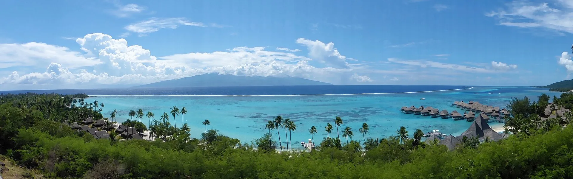 Lagon turquoise de Moorea avec bungalows sur pilotis et montagnes en arrière-plan